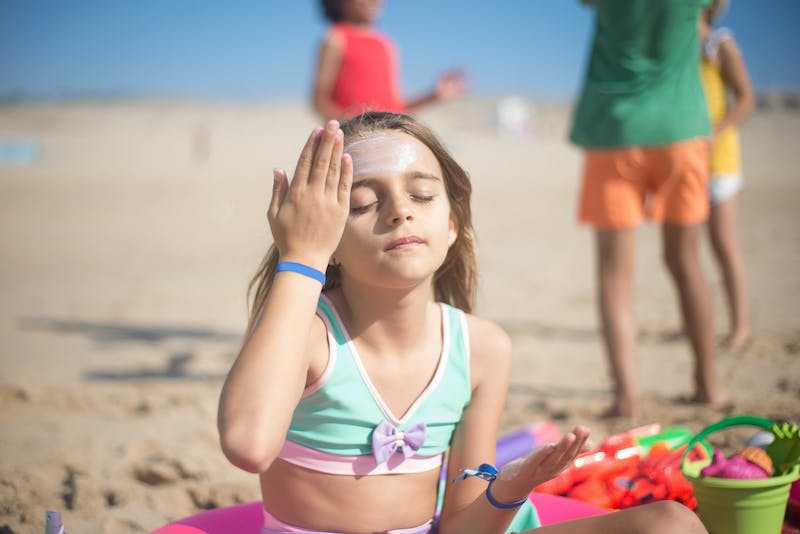 Girl applying sunscreen on face