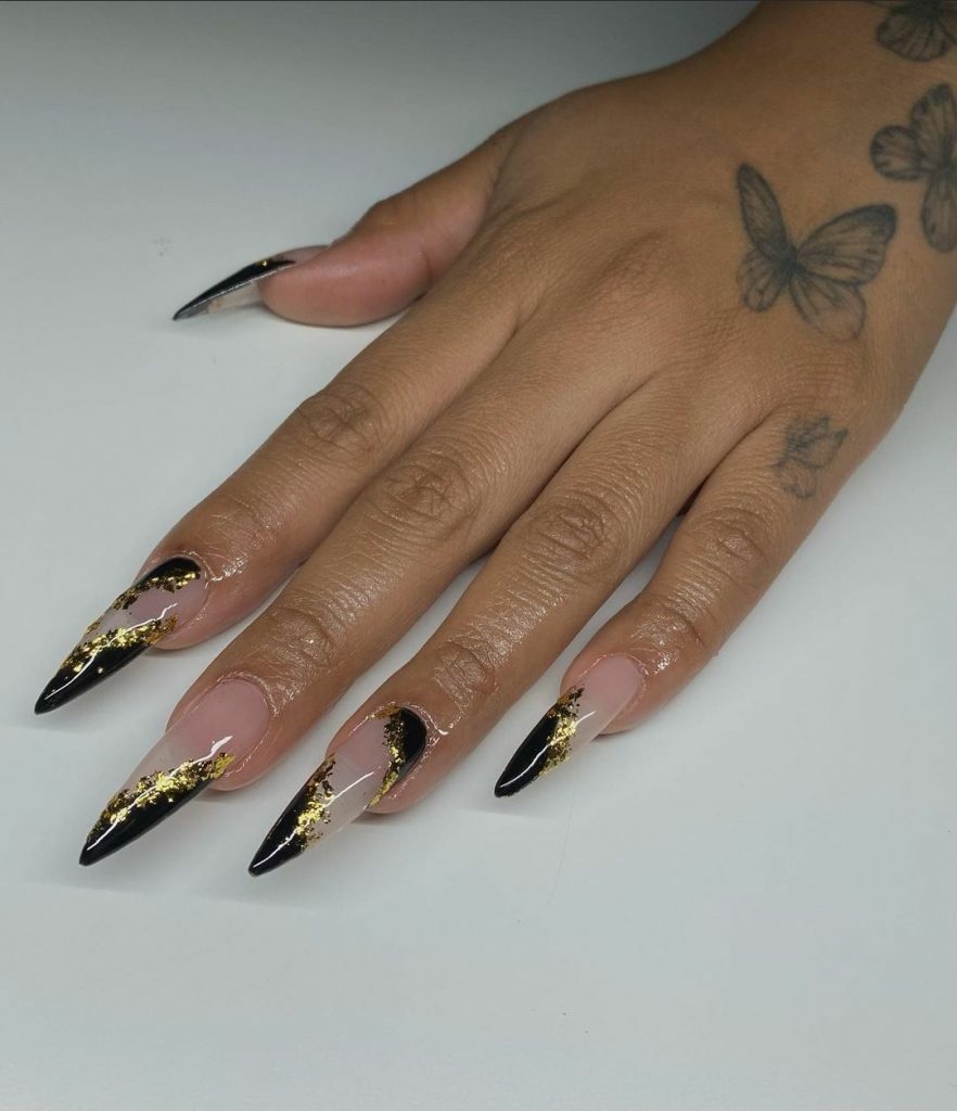 Edgy yet classy stiletto black and gold nails