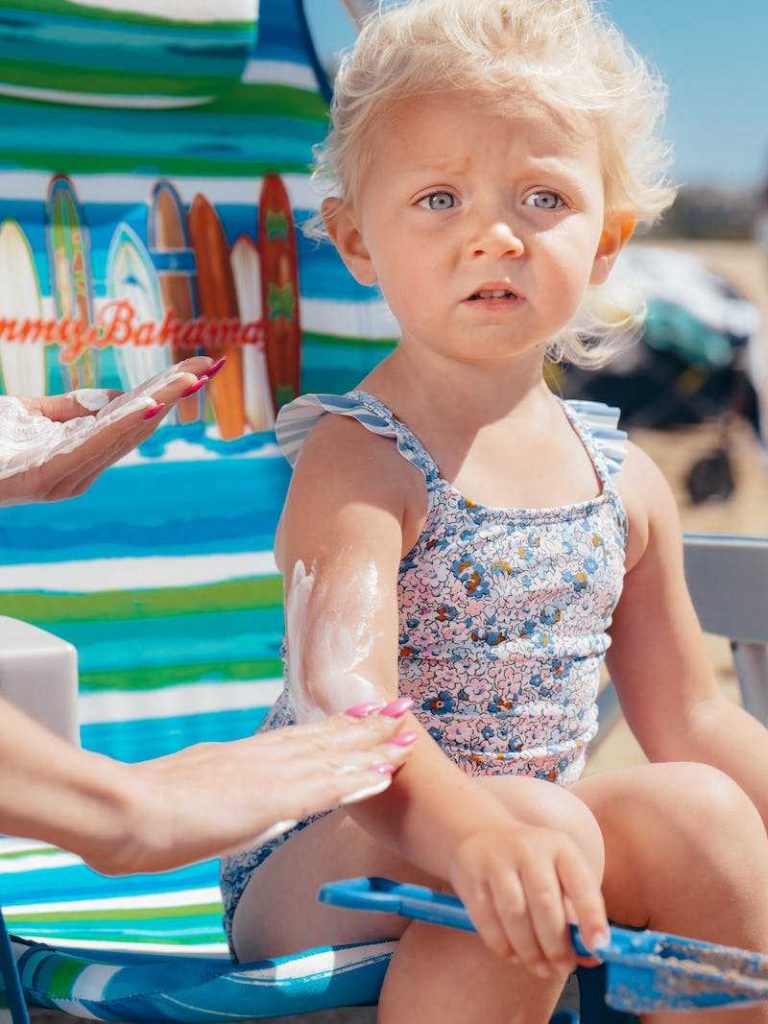 Woman applying sunscreen on a child
