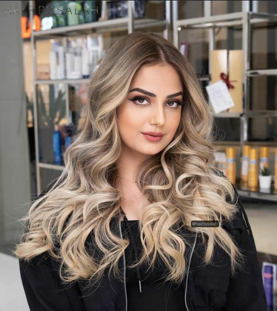 Light beige blonde hair color with face framing highlights. 