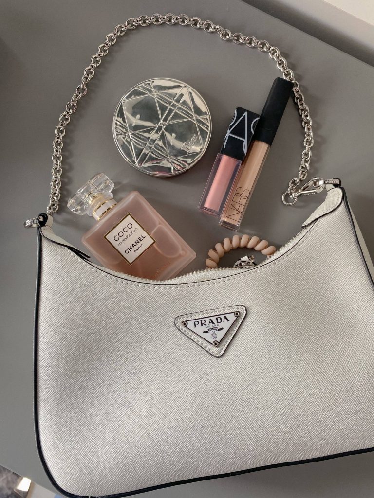 stylish handbag with perfume and makeup