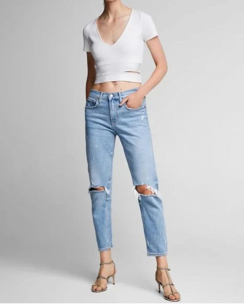woman wearing a mid rise distressed jeans