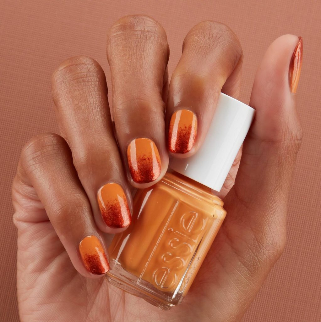 Orange and red shimmery ombre nails.