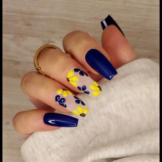 Nails featuring blue and yellow flowers.