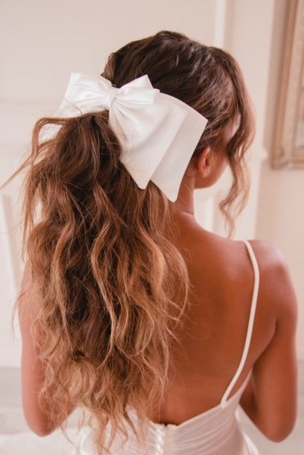 Curly bridal hairstyle with a cute bow.