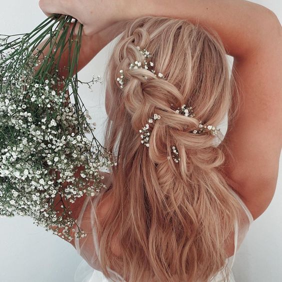 Dutch braids adorned with fresh flowers.
