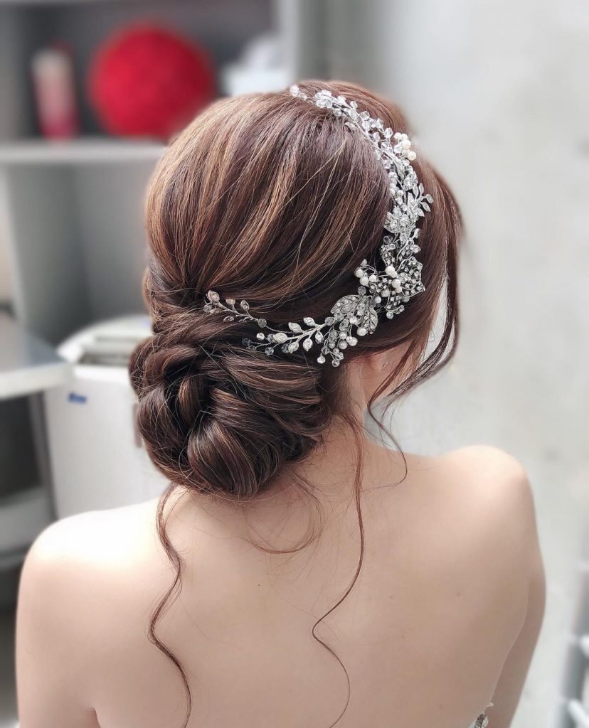 Low twisted bun wedding hairstyle with braid