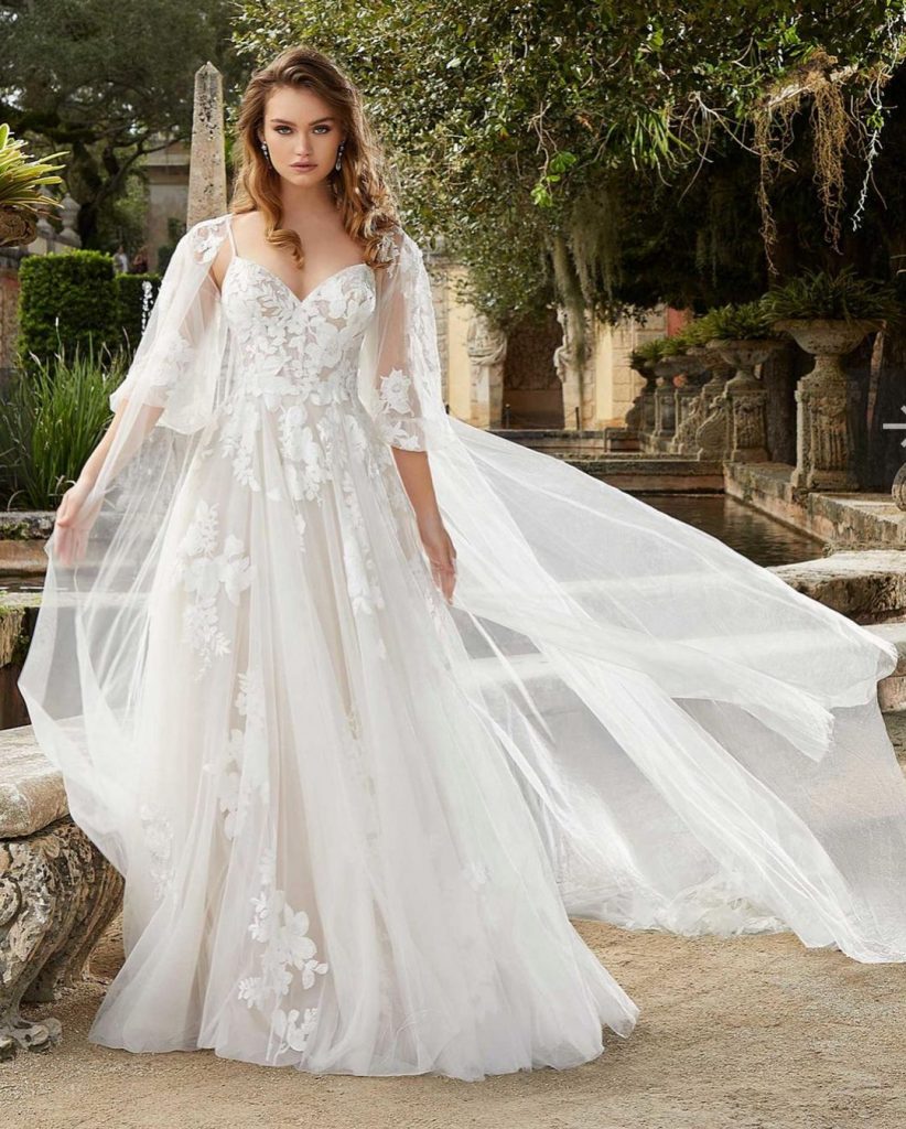 Floral A-line bridal gown adorned with cape.