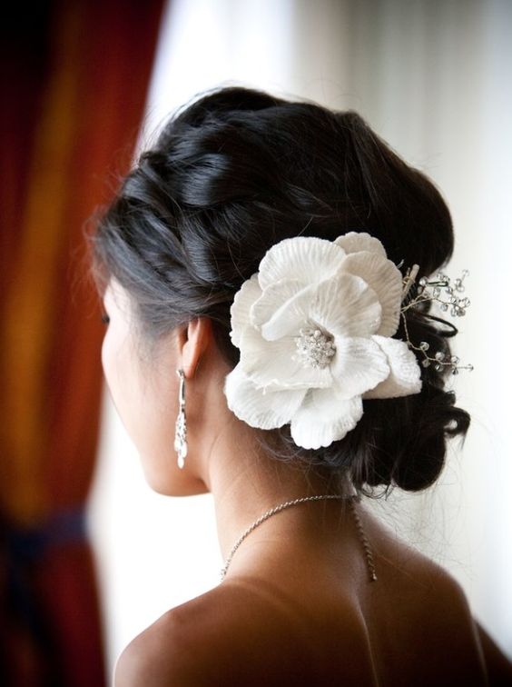 Low chignon with delicate floral accents.
