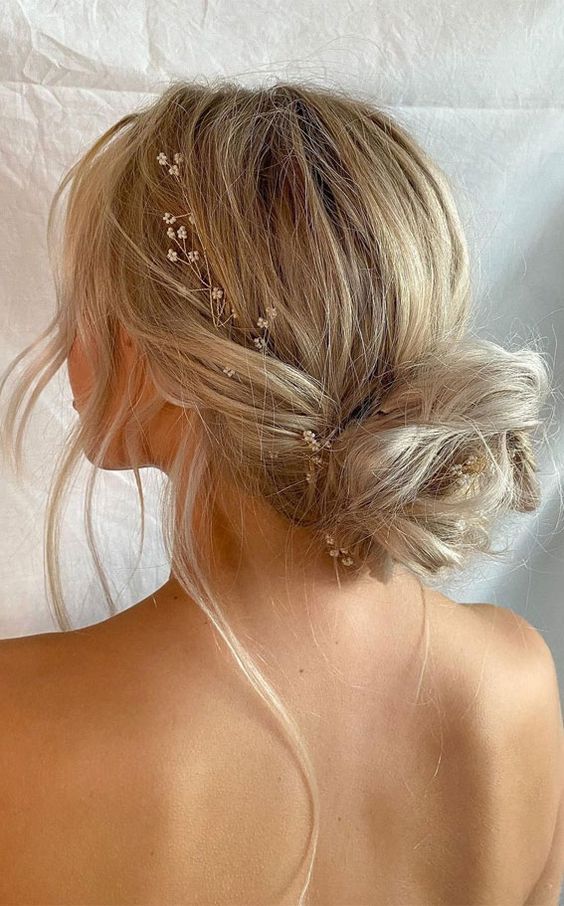 Messy bun with a jeweled hairpin accent.