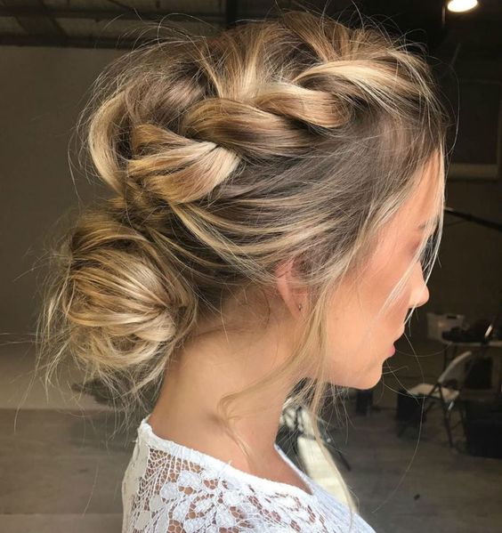 Messy braids formed into a low bun.