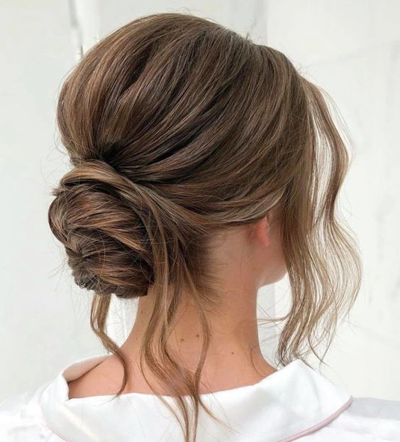 Low, messy bun with tendrils