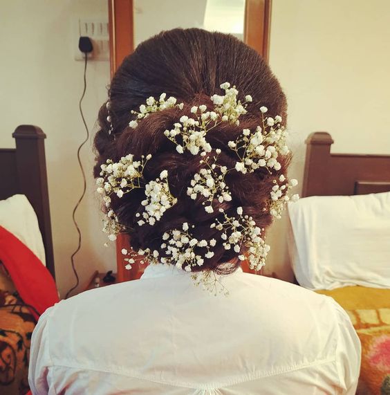 wedding guest hair look inspired braided bun with baby's breath