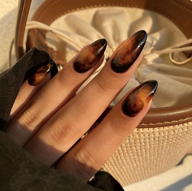 Glamorous black & amber almond nails shades.