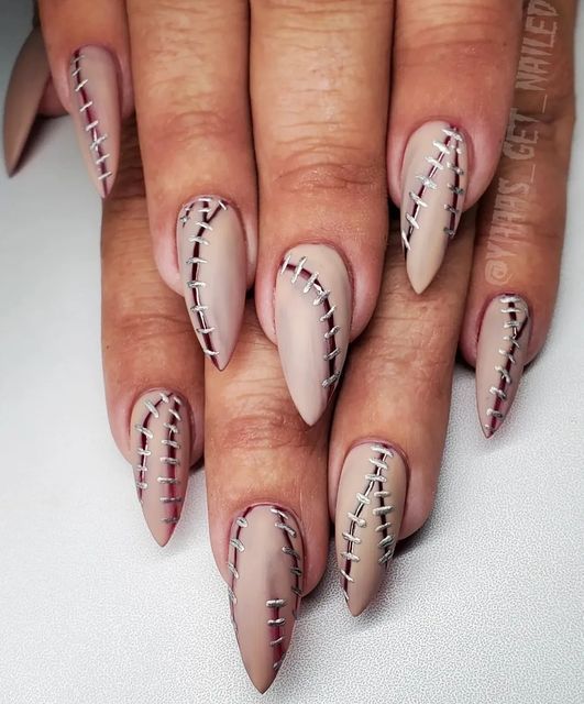 Zombie skin stitch-inspired spooky nails.