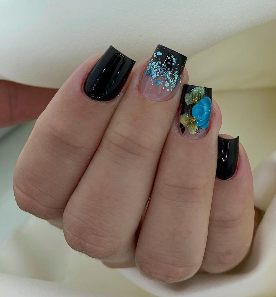 Glossy black square nails with glitter.