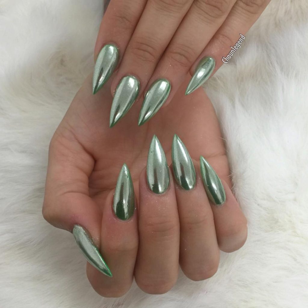 Stiletto nails in emerald green with a chrome finish.