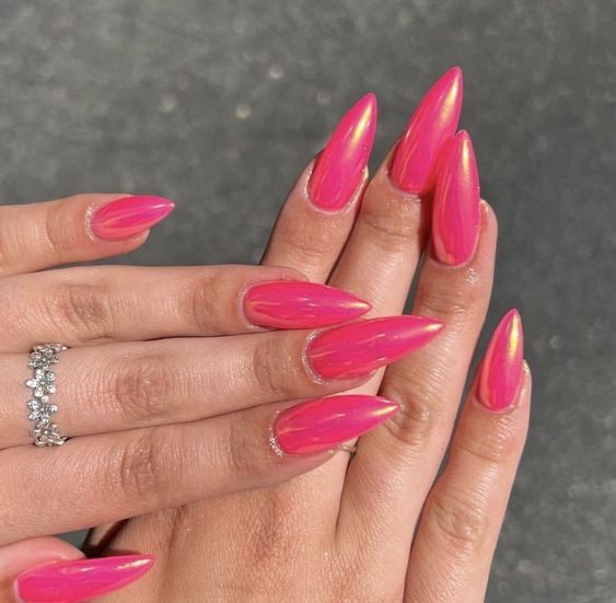 Pointed almond nails in neon pink with chrome accents.