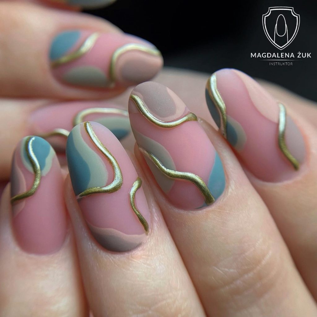 Pastel block nails with golden 3D swirls.