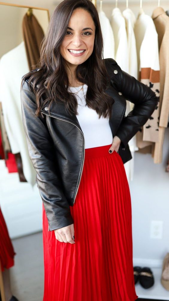 a woman in black leather jacket and red skirt