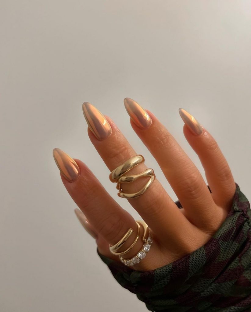 Shiny golden almond-shaped chrome nails.