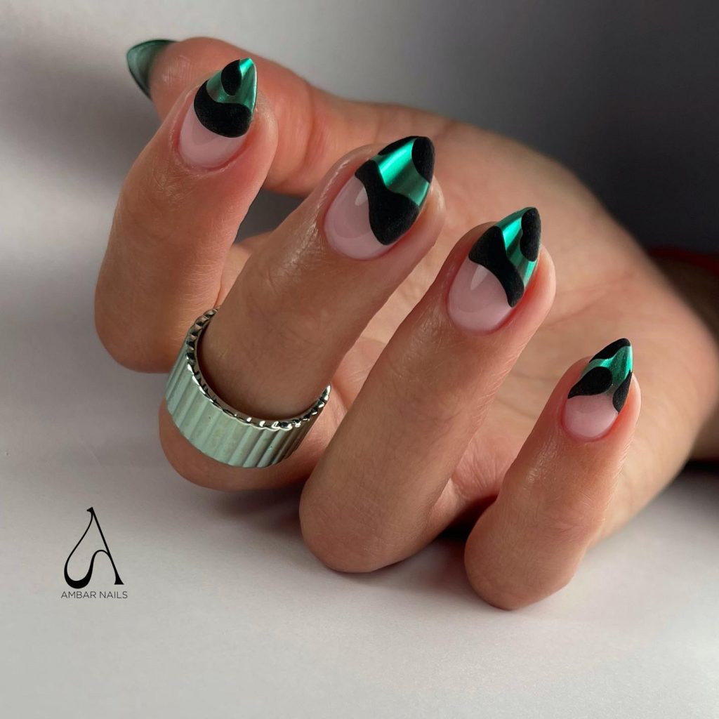 Wavy-patterned nails with green chrome on matte black.