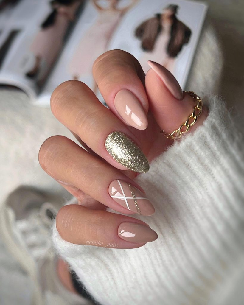 Opulent gold accents on short almond-shaped nude nails.