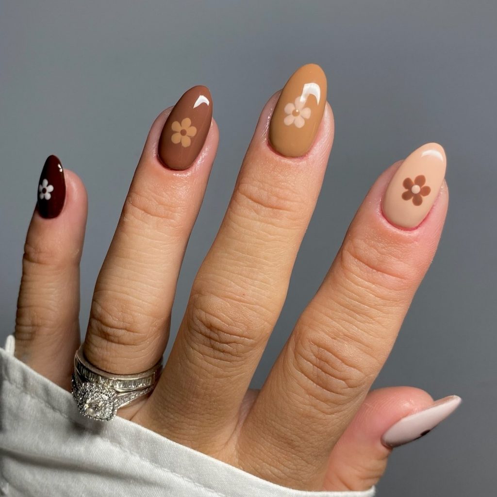 Earthy tones and floral charm on nude nails.