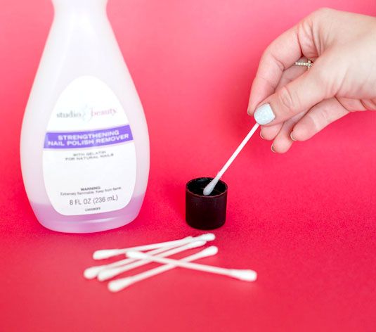 cleaning the nail edges with cotton swabs and remover