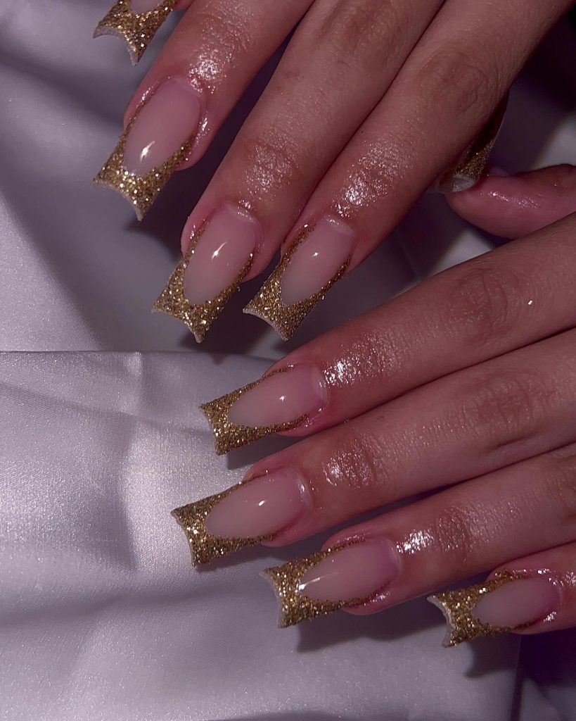 Shimmery gold French tip nails for a glamorous party.