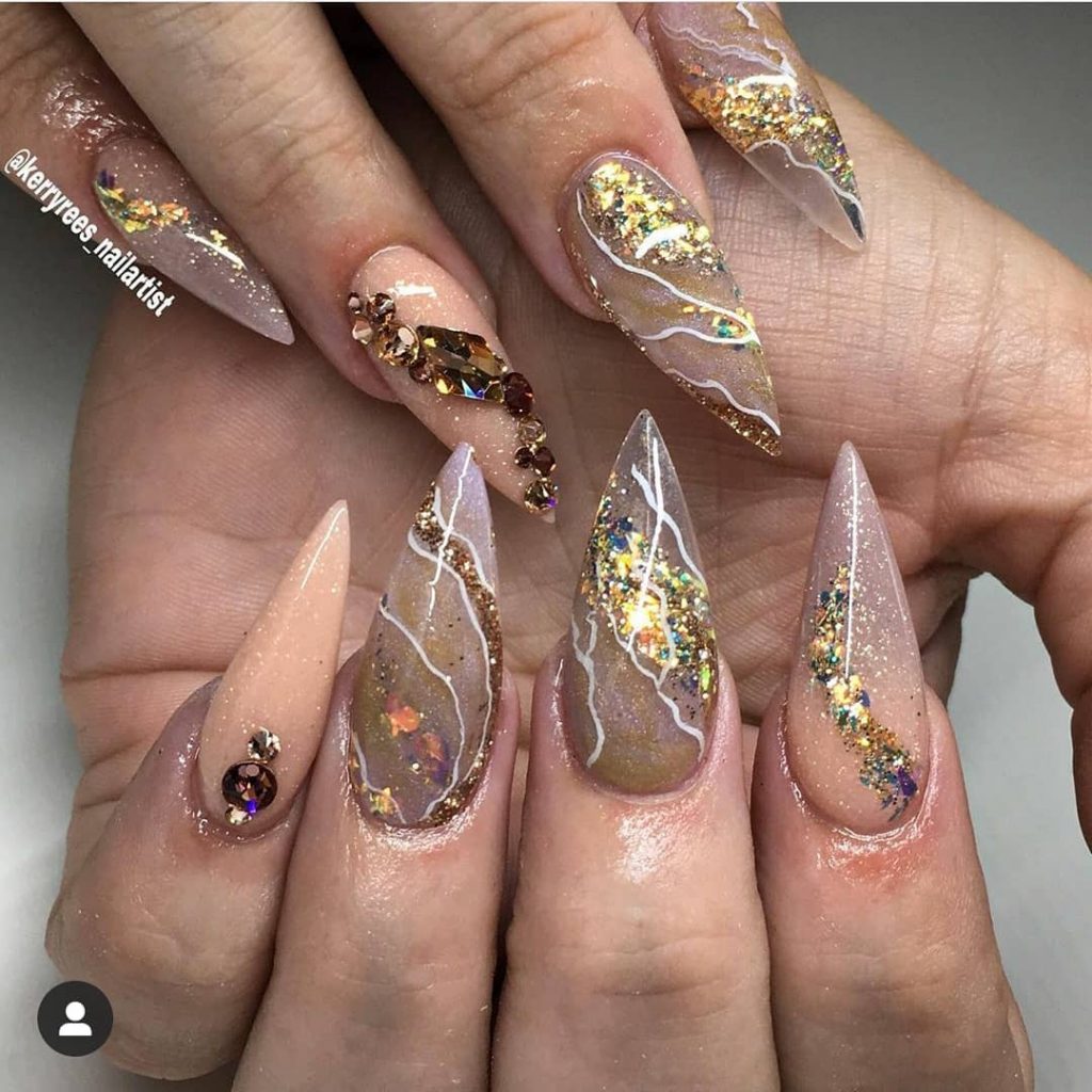 Opulent gold glittery stiletto on acrylic nails.