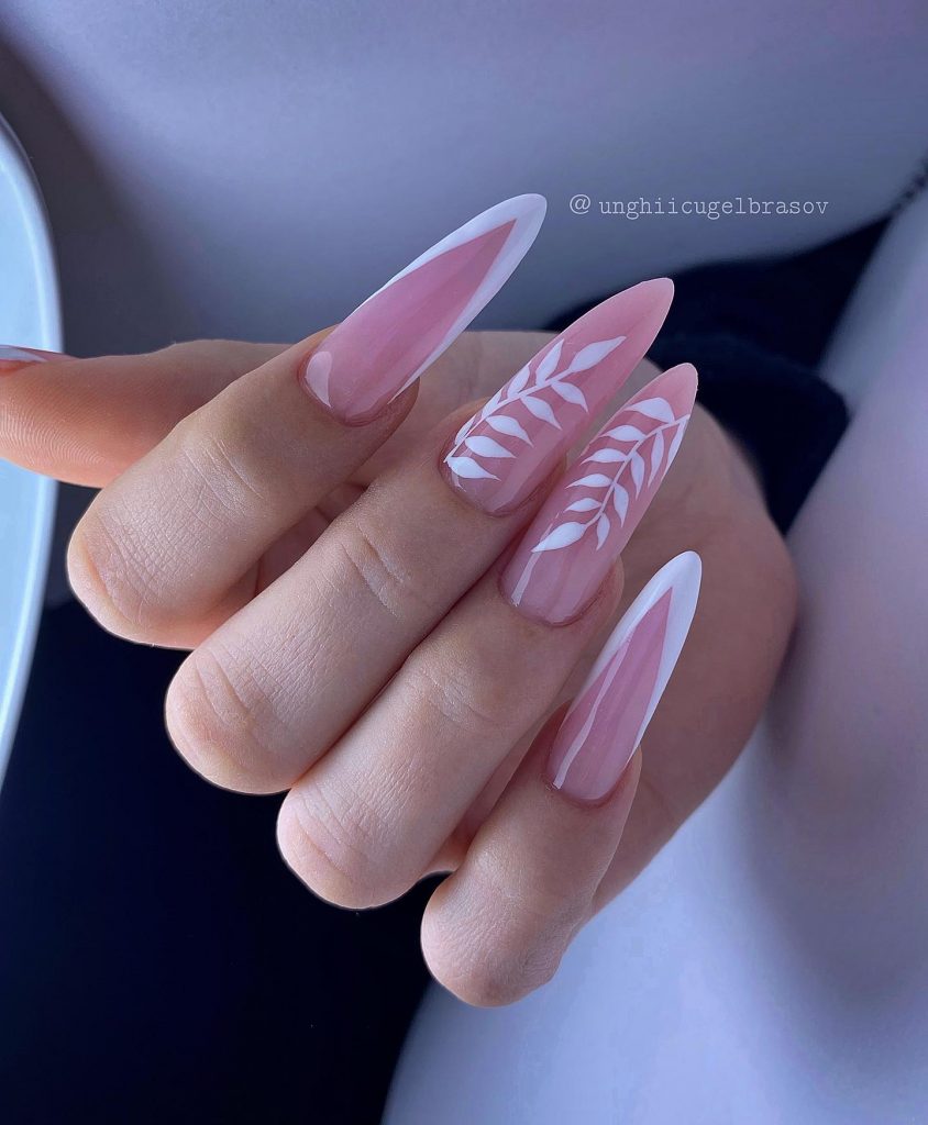 Subtle leaf design on almond-shaped nude nails.