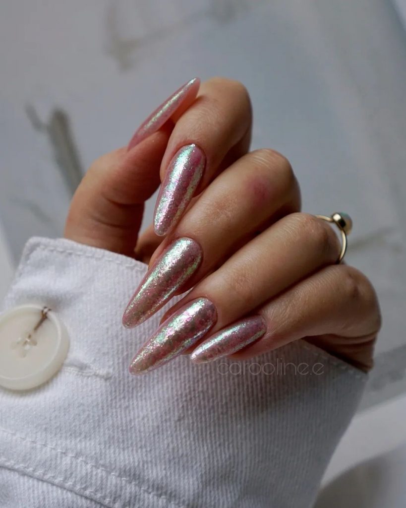 Long almond-shaped nails in delicate pink with silver accents.