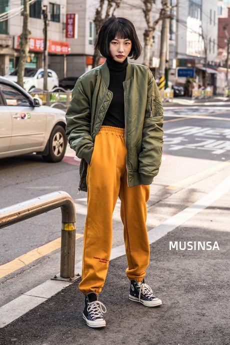 Green bomber jacket with yellow sweatpants.