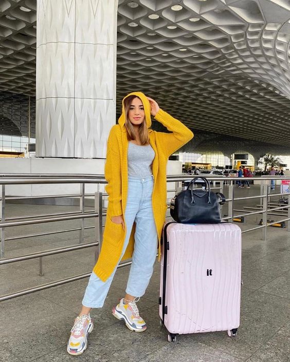 Vibrant yellow overcoat adds flair to airport-ready gray tank top.