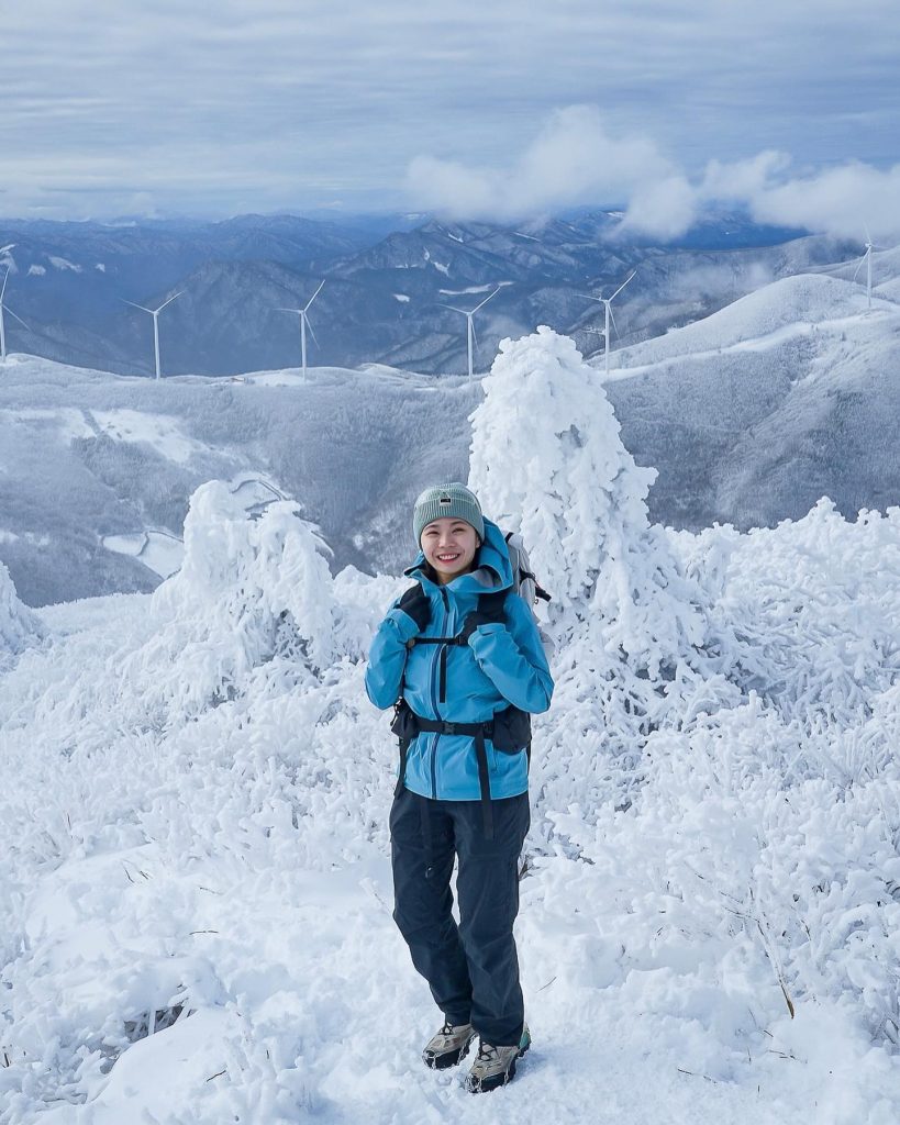 woman standing in a snow covered mountain