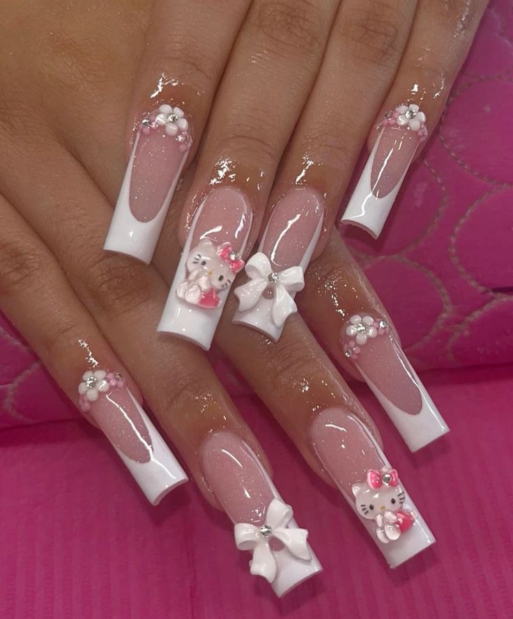 long nude acrylic nails with white French tips and Hello Kitty embellishments